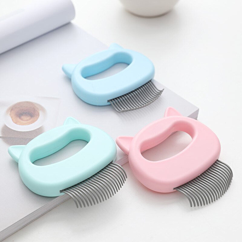 Three pastel-colored Feline Shell Massage Comb - Whisker-Friendly Soft-Needle Deshedding Tools in blue, pink, and mint green with ergonomic handles shaped like cat heads on a white surface.