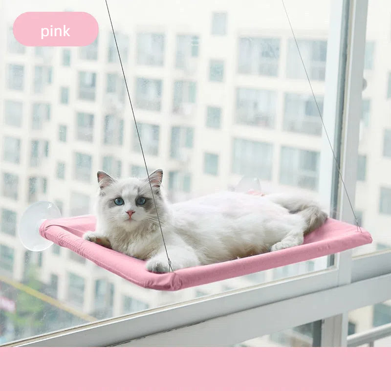 Foldable Cat Window Hammock - Space-Saving Suction Cup Perch & Elevated Sunbed in pink, mounted on a window with a white cat resting comfortably on it.