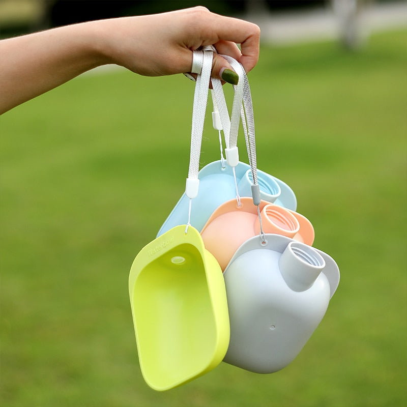 Hand holding three Universal Pet Hydration Adapter – Portable Bottle Attachment & Travel Drinking Scoop in pastel green, peach, and light blue, designed for on-the-go pet hydration.