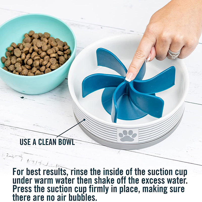 Hand pressing the blue spiral insert inside a white pet bowl, demonstrating the Universal Propeller Slow Feeder Insert - Spiral Anti-Gulping Solution next to a bowl of dry pet food.