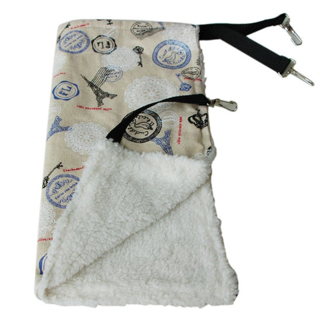 Thermal Hanging Cat Hammock - Double-Sided Winter Warm Fleece Bed for Cages, Crates & Chairs with a soft white fleece interior and a printed outer fabric featuring travel-themed designs.