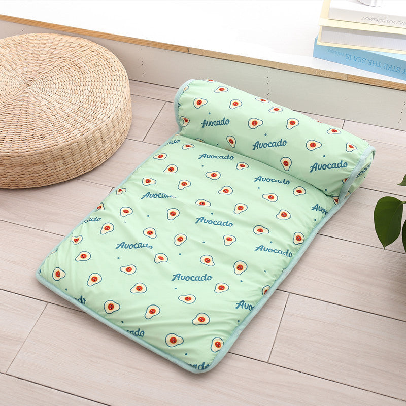 Boutique Ice-Silk Cooling Mat - Patterned Heatstroke Prevention Sleeping Bed featuring a light green avocado design, placed on a wooden floor beside a woven round cushion and stacked books.