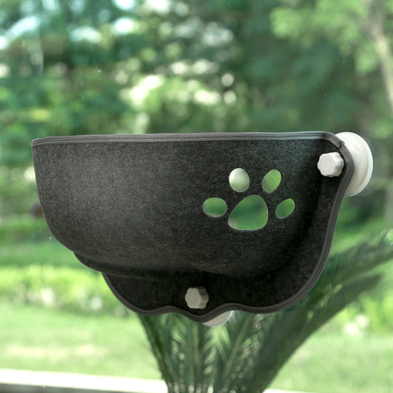 Luxury Felt Cat Window Pod - Designer Glass-Mounted Sun Lounger & Private Hideaway made of dark felt with a paw print cutout, securely attached to a window overlooking greenery.