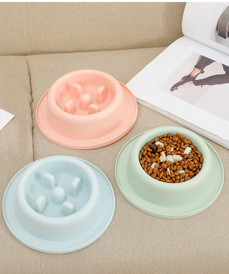 Three pastel-colored Minimalist Slow Feeder - Modern Anti-Vomit Bowl for Cats & Dogs arranged on a beige couch, one filled with dry pet food and treats.