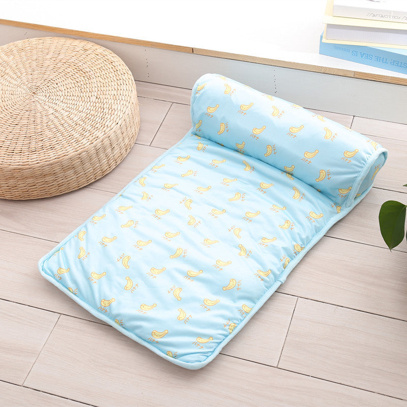 Boutique Ice-Silk Cooling Mat - Patterned Heatstroke Prevention Sleeping Bed in light blue with yellow bird design, rolled partially, placed on a wooden floor next to a round woven cushion.