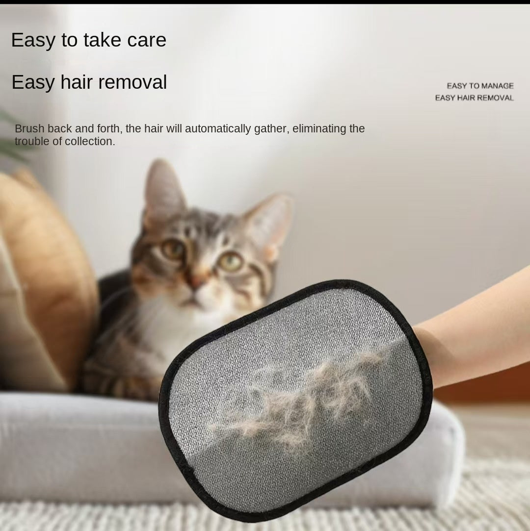 Hand holding the Electrostatic Pet Hair Removal Glove - Bidirectional Grooming & Fabric Cleaner with collected pet hair visible on the glove, with a cat sitting on a blurred couch in the background.