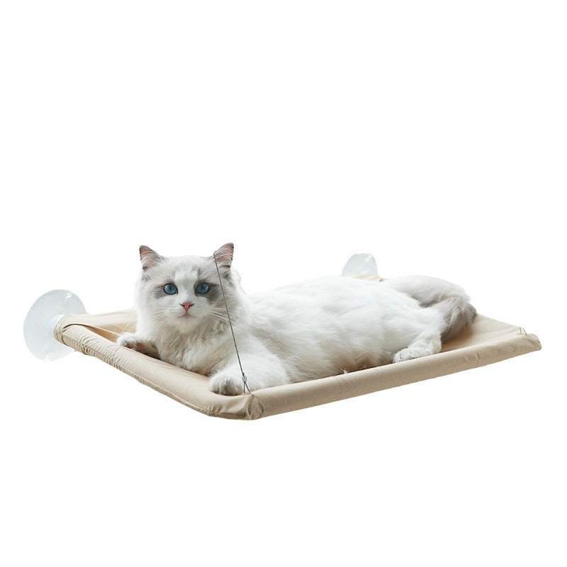 White cat with blue eyes resting comfortably on a beige Foldable Cat Window Hammock - Space-Saving Suction Cup Perch & Elevated Sunbed attached to a glass surface.