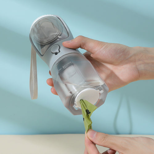 Person dispensing waste bag from a compact portable device designed as the 3-in-1 Pet Travel Station – Integrated Water, Food & Waste Management for convenient pet care on the go.