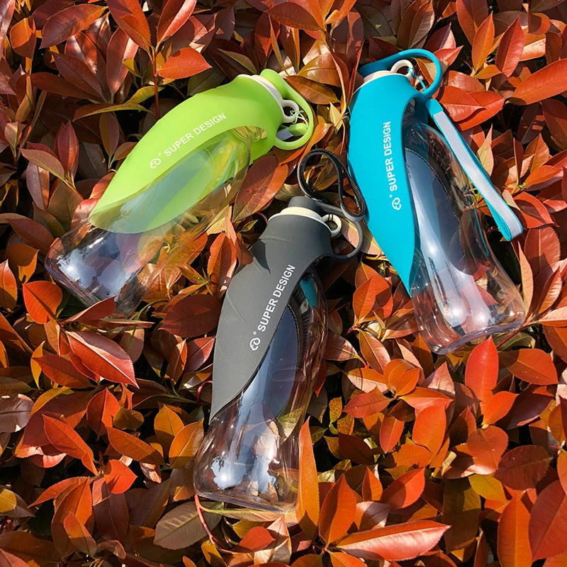 Three Large Silicone Leaf Bottle - 580ml Portable Travel Bottle in green, blue, and black resting on orange foliage outdoors.