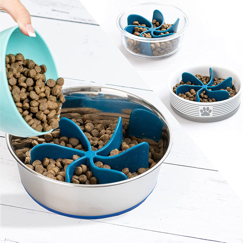 Dog food bowl with a blue Universal Propeller Slow Feeder Insert - Spiral Anti-Gulping Solution slowing down feeding in a stainless steel bowl, with dry kibble being poured in.