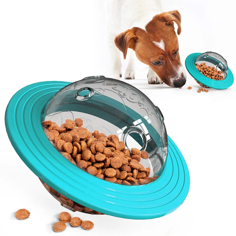 A brown and white dog interacting with an Interactive Flying Saucer Puzzle Feeder - IQ Training & Slow Feed Toy featuring a turquoise outer ring and a transparent dome filled with kibble.